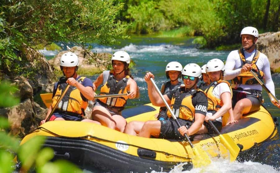 Bali: Telaga Waja White Water River Guided Rafting & Lunch - Green rice fields, cliffs, and waterfalls from the raft