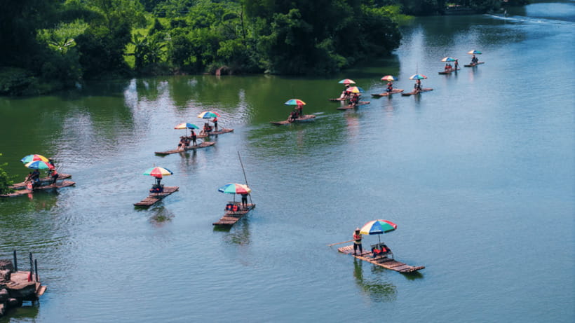 Yangshuo: Yulong River Bamboo Rafting Experience - Karst peaks, river greenery, and old bridges
